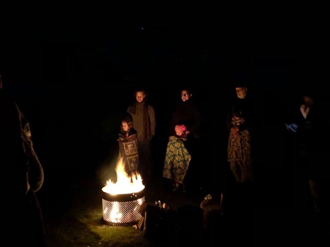 People at night standing around a bonfire.
