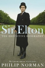 Book cover with Sir Elton John in a top hat, coat and cane. Sir Elton, The Definitive Biography by Philip Norman.